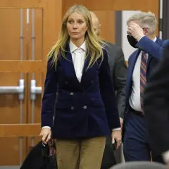 Gwyneth Paltrow w granatowym aksamitnym żakiecie i sztruksowych spodniach, uosobienie cichego luksusu, wychodzi z sali sądowej.