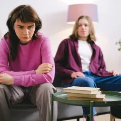 Smutna kobieta siedzi obok mężczyzny, czując ciężar trudnych relacji, jakby doświadczyła wpływu toksycznego ojca.