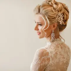 Eleganckie fryzury na wesele średnie włosy upięcia. Delikatne loki i perłowa ozdoba we włosach panny młodej.