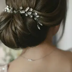 Eleganckie, luźne upięcia ślubne z delikatną biżuterią. Warkocz ozdobiony kryształkami dodaje blasku.