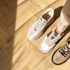 Beżowe sneakersy i półbuty na drewnianej podłodze. Idealne buty do cygaretek na co dzień i do pracy.