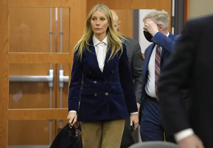 Gwyneth Paltrow w granatowym aksamitnym żakiecie i sztruksowych spodniach, uosobienie cichego luksusu, wychodzi z sali sądowej.