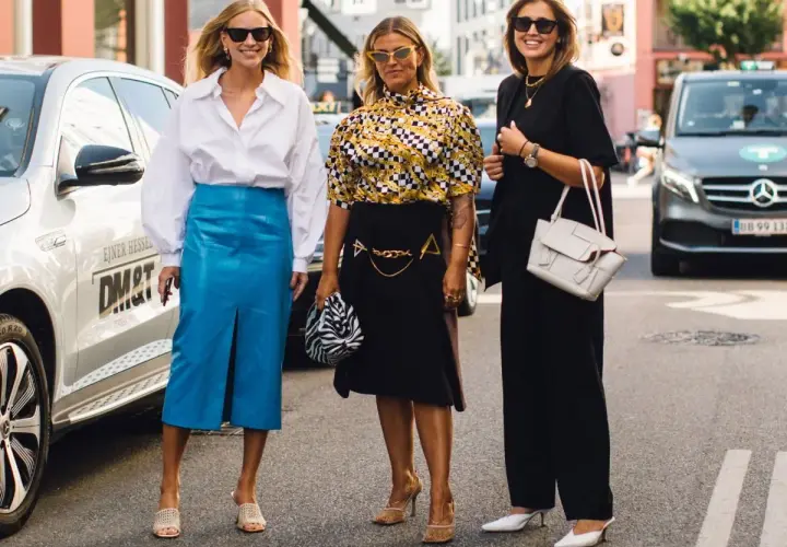Trzy kobiety prezentują stylowe propozycje, jak się ubrać na Wielkanoc: biała koszula i niebieska spódnica, wzorzysta bluzka i czarna spódnica, czarny total look.