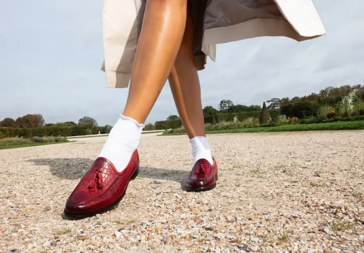 Eleganckie, czerwone buty damskie z frędzlami, idealne do jesiennych stylizacji w ogrodzie.