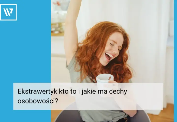 Radosna rudowłosa kobieta z kubkiem w dłoni, z ręką w górze. Czy to ekstrawertyk? Tekst: "Ekstrawertyk kto to i jakie ma cechy osobowości?".