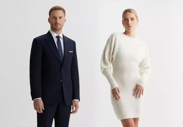 Elegancki mężczyzna w granatowym garniturze i kobieta w kremowej sukience. Idealne stylizacje, jak się ubrać na wigilię firmową.