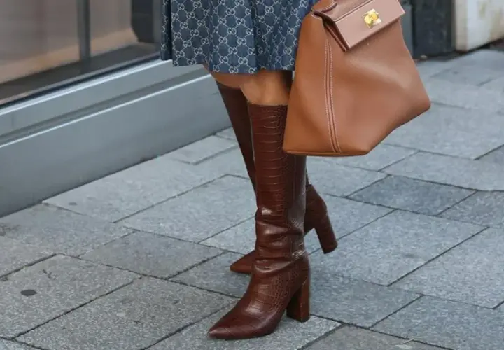 Eleganckie kozaki za kolano w brązowym kolorze, z fakturą skóry krokodyla, idealne na imprezę. Stylizacja uzupełniona o torebkę w tym samym odcieniu.