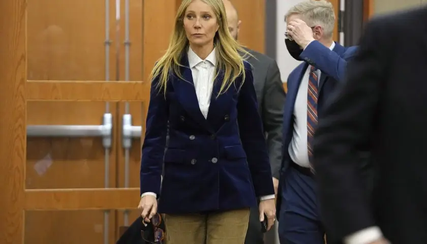 Gwyneth Paltrow w granatowym aksamitnym żakiecie i sztruksowych spodniach, uosobienie cichego luksusu, wychodzi z sali sądowej.