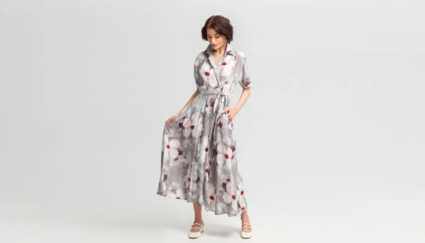 Elegancka stylizacja na wieczór: zwiewna sukienka maxi w kwiaty, z wiązaniem w talii i dekoltem koszulowym.