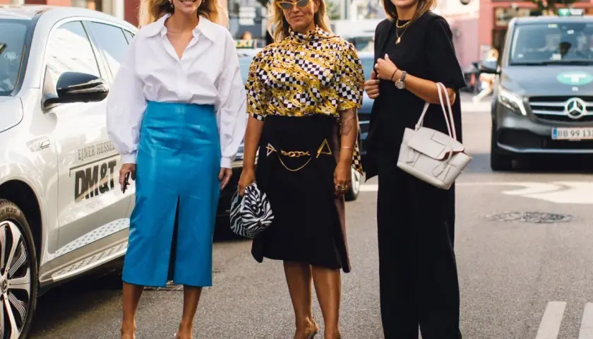 Trzy kobiety prezentują stylowe propozycje, jak się ubrać na Wielkanoc: biała koszula i niebieska spódnica, wzorzysta bluzka i czarna spódnica, czarny total look.