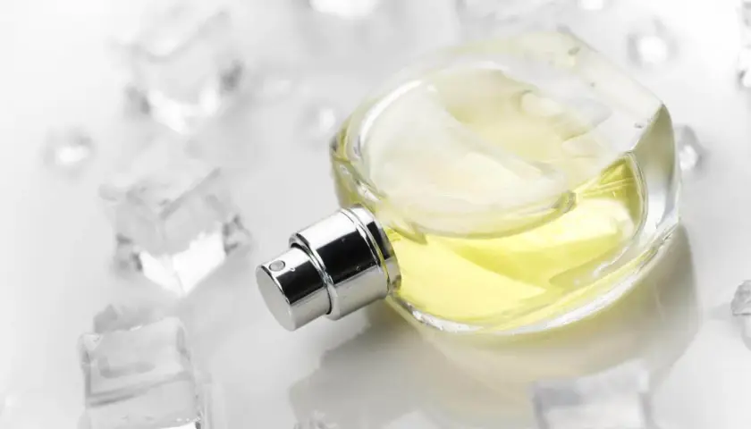 Eleganckie perfumy szyprowe w szklanej butelce, otoczone kostkami lodu. Chłodna elegancja i świeżość.