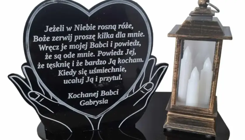 Serce z napisem "Kochanej Babci Gabrysia" i cytatem, obok lampion z białymi świecami. Wzruszające cytaty dla zmarłego dziadka i babci.