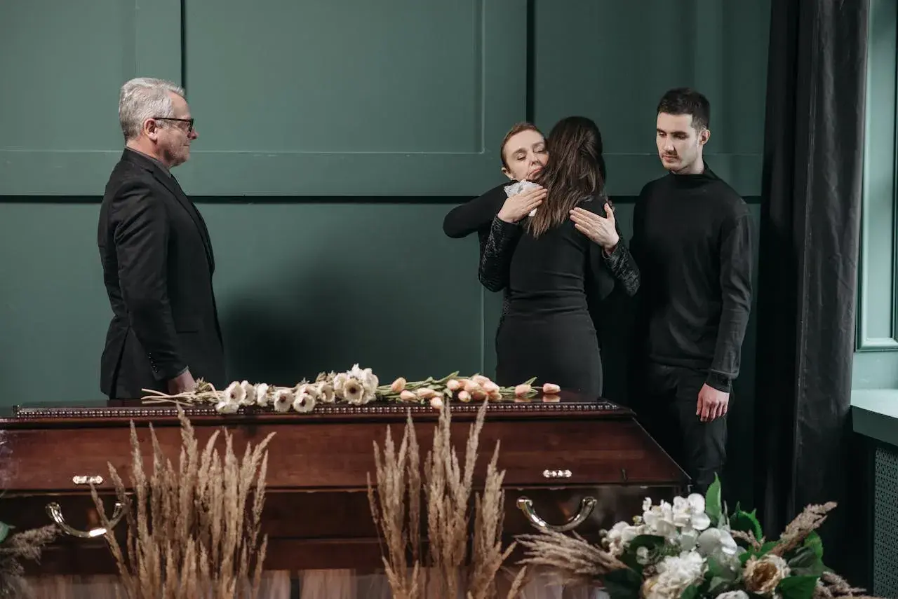 Smutek i żałoba. Rodzina w czerni przy trumnie. Jak się ubrać na pogrzeb? Elegancko i z szacunkiem.