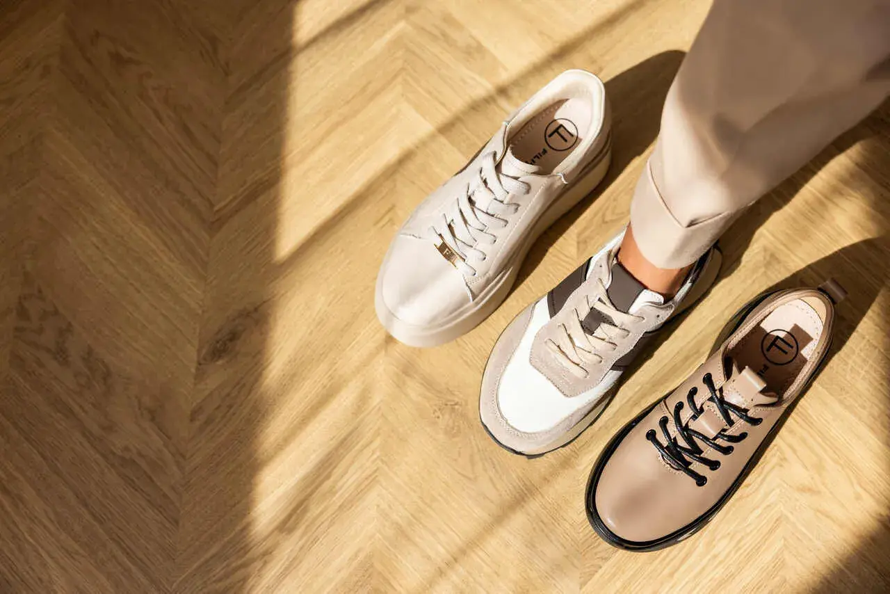 Beżowe sneakersy i półbuty na drewnianej podłodze. Idealne buty do cygaretek na co dzień i do pracy.