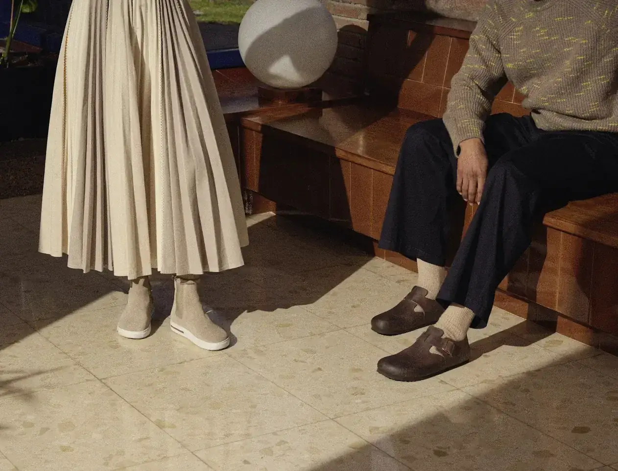 Elegancka jesienna stylizacja: plisowana spódnica i sweter z zamszowymi botkami lub półbutami.