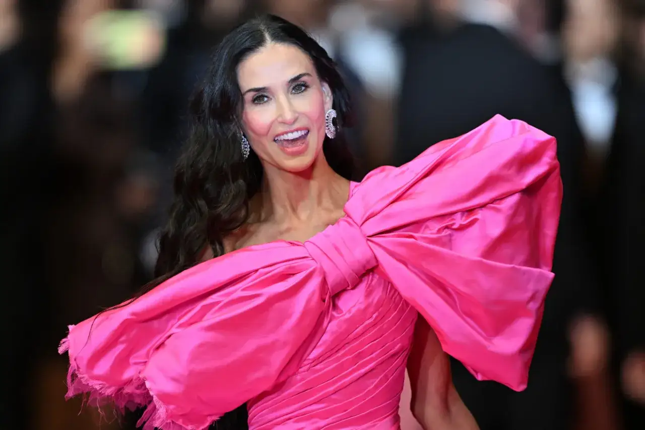 Demi Moore w olśniewającej różowej sukni z kokardą. Inspiracja, jak się ubrać na festiwal, by wyglądać zjawiskowo.
