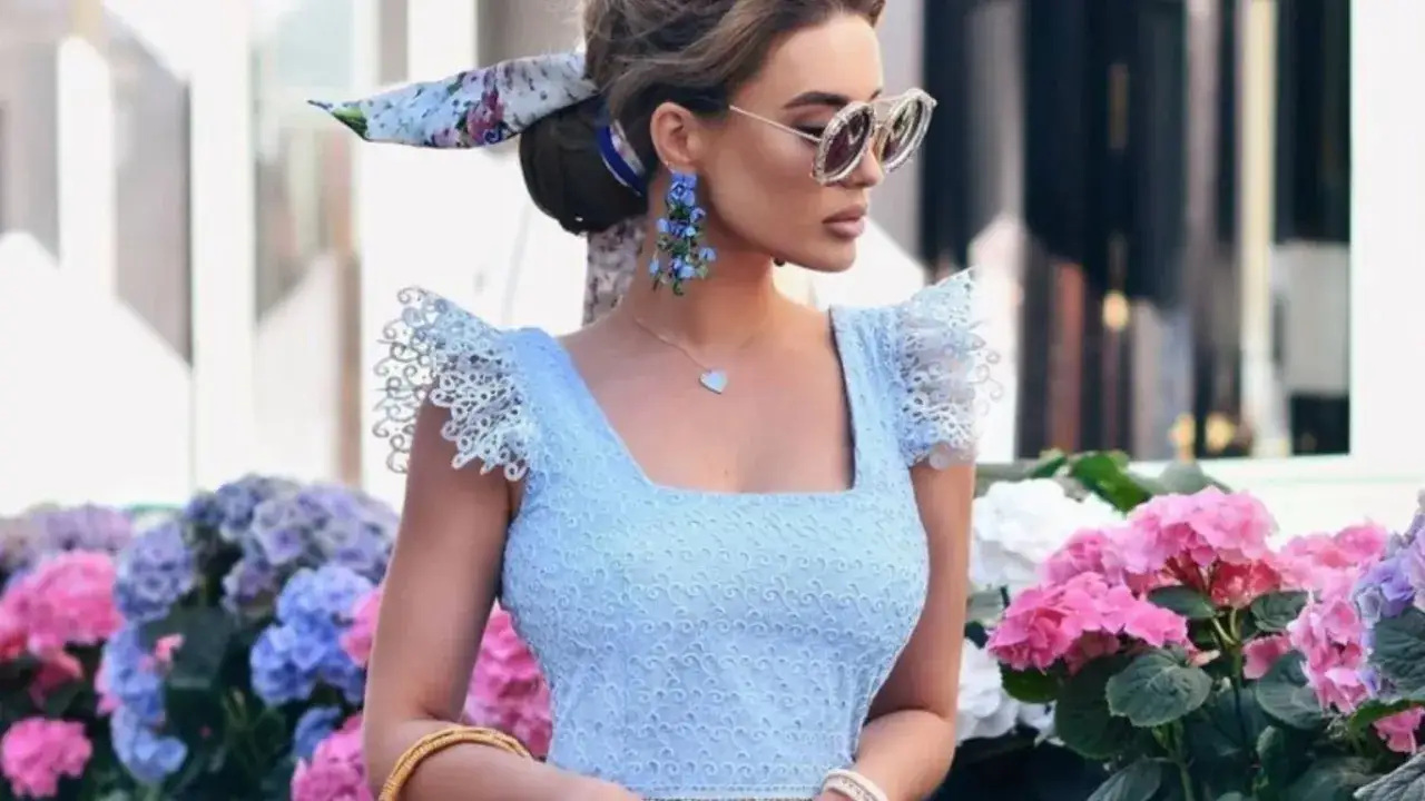 Elegancka błękitna sukienka z koronkowymi rękawami, idealna na stylizacje na wesele. Dopełniona kwiatowymi kolczykami i apaszką.