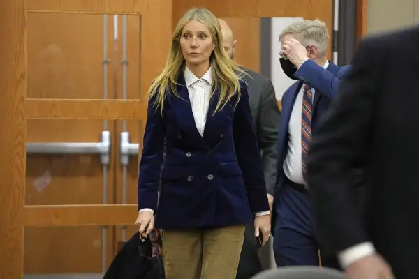Gwyneth Paltrow w granatowym aksamitnym żakiecie i sztruksowych spodniach, uosobienie cichego luksusu, wychodzi z sali sądowej.