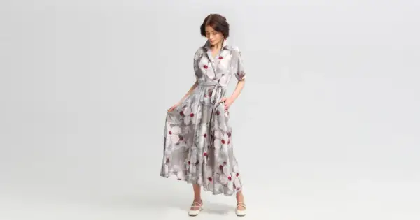 Elegancka stylizacja na wieczór: zwiewna sukienka maxi w kwiaty, z wiązaniem w talii i dekoltem koszulowym.